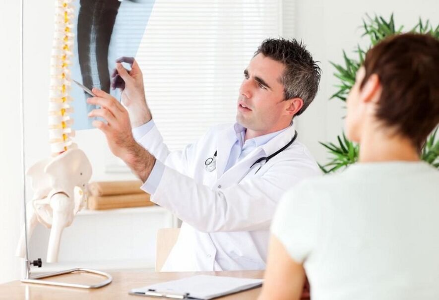 The doctor examines an X-ray to diagnose thoracic osteochondrosis